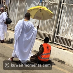 Pilgrim Uses Umbrella to Shade Hajj Security